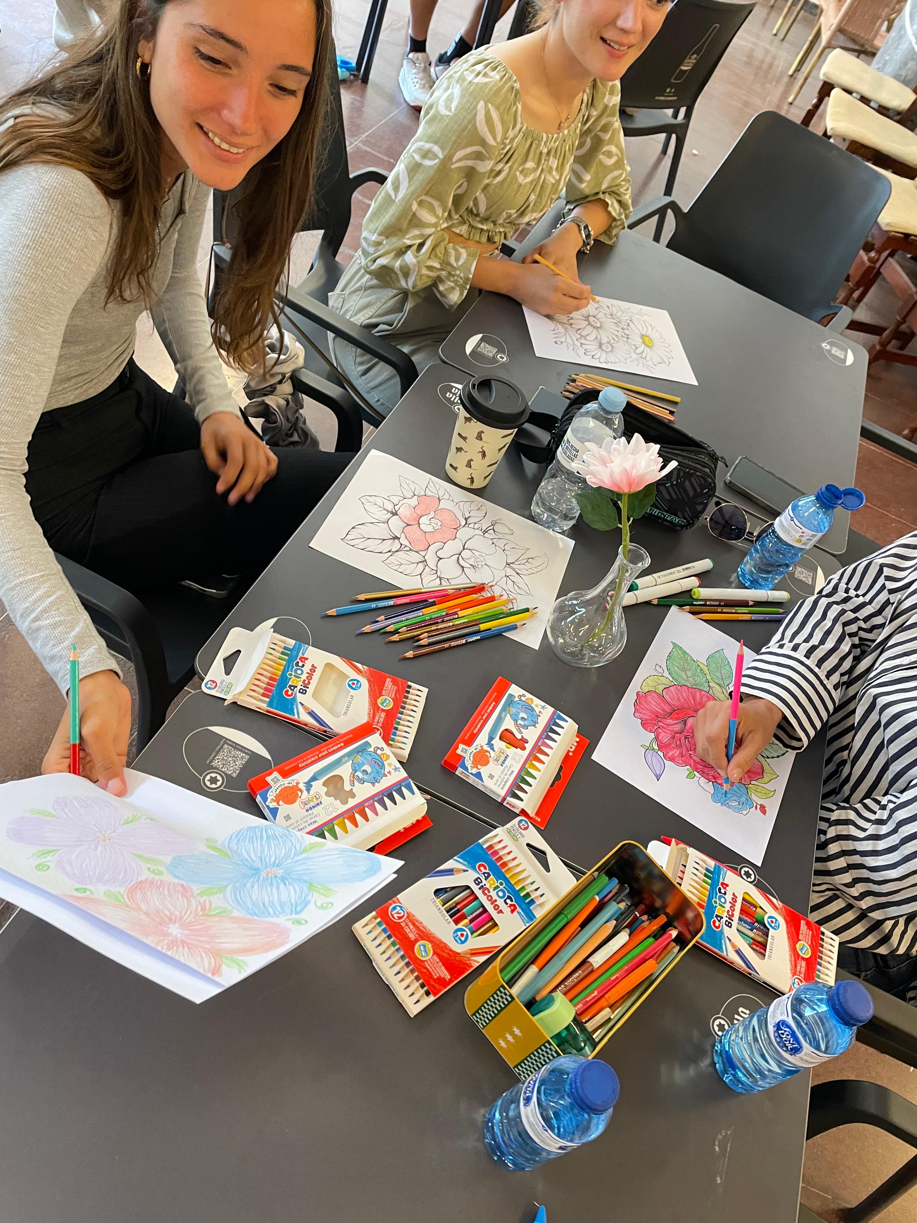 Participantes adultas dibujando flores con lápices de colores